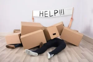 a person lying on the floor and surrounded by boxes