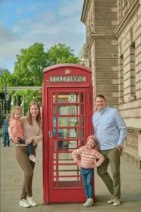 Happy family posing close by a Red Booth in London